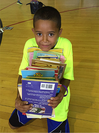 Child holding a stack of books